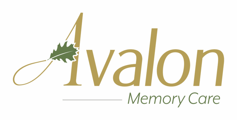 Logo for Avalon Memory Care. The word Avalon is written in gold with a green oak leaf crossing the letter A. Below Avalon, the words Memory Care appear in green on a white background.
