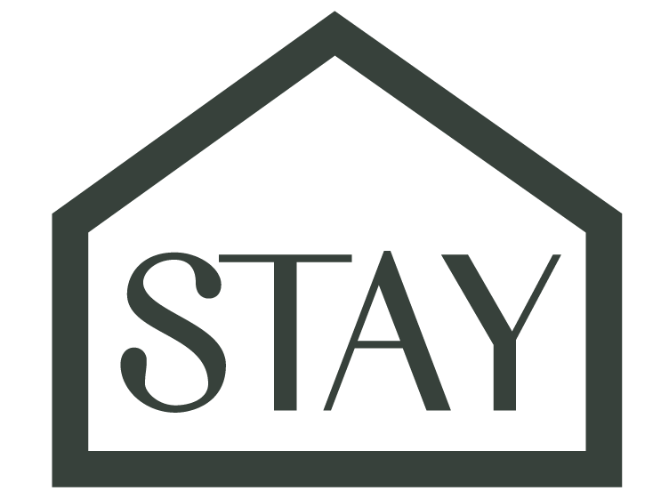 The word STAY is written in large, bold letters inside the outline of a simple house shape, suggesting the concept of staying at home or shelter.